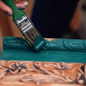 macro on a brush in paint and the process of refreshing an old box with monograms, restoring antique objects and moderate consumption.